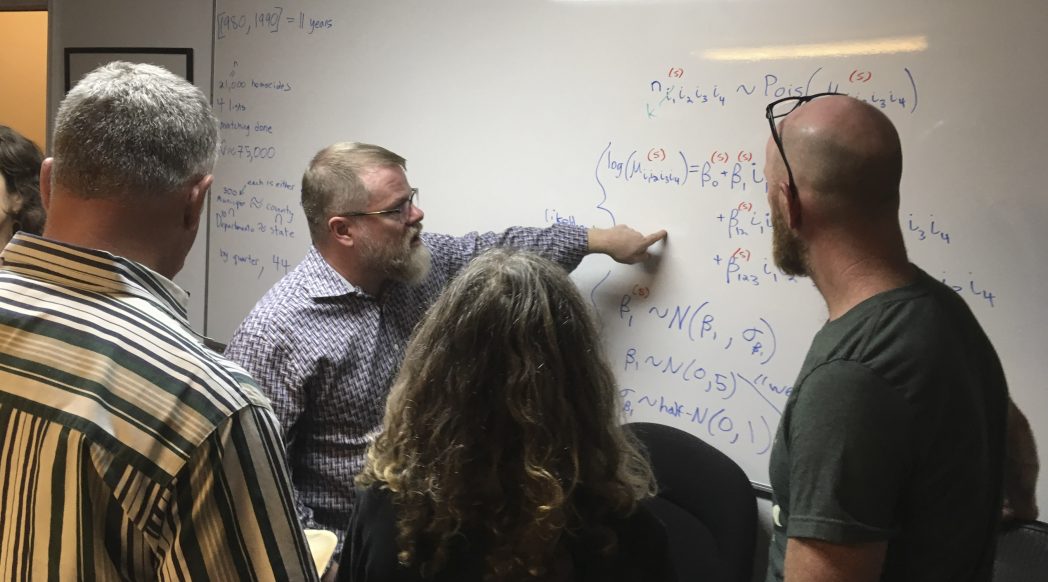 Patrick Ball explaining math at a whiteboard.