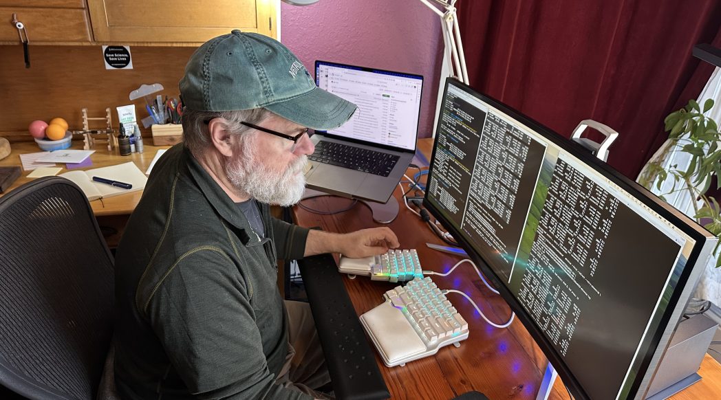 Patrick Ball working at three monitors